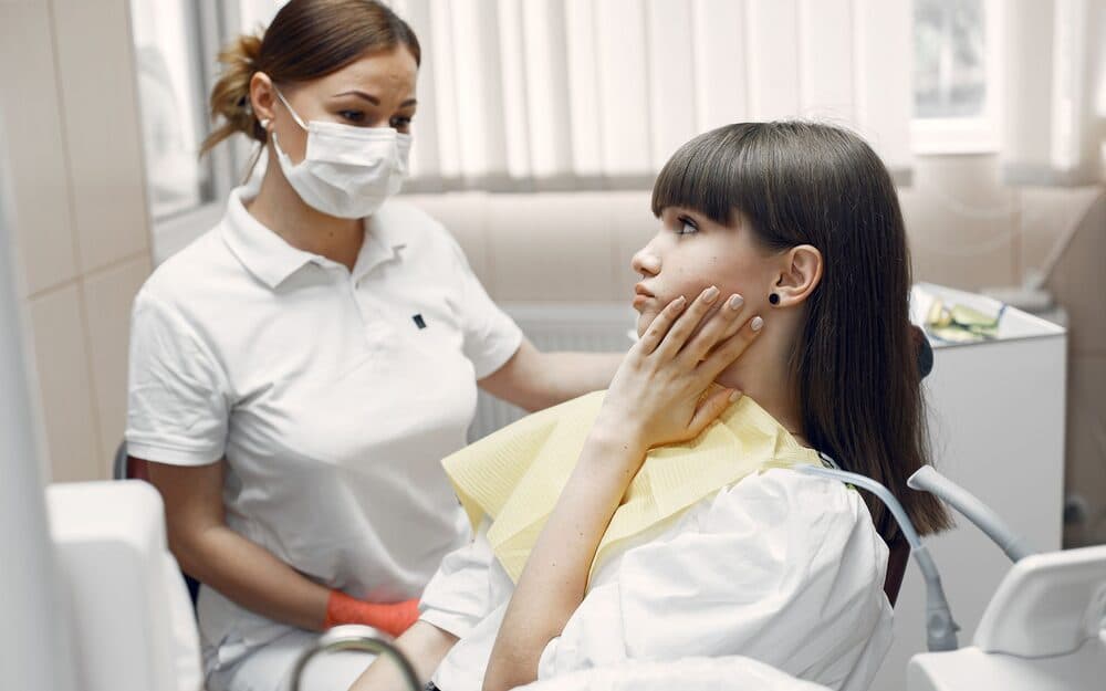 A dentist reassuring a patient in the treatment chair