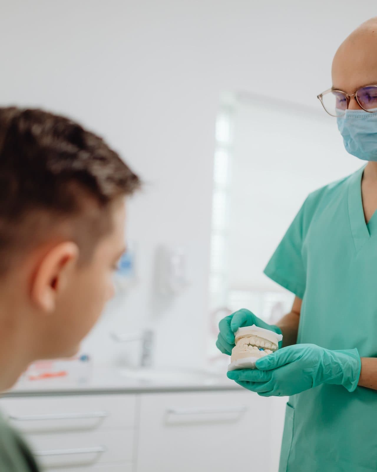 A dentist and a smiling patient in a Synergy treatment room