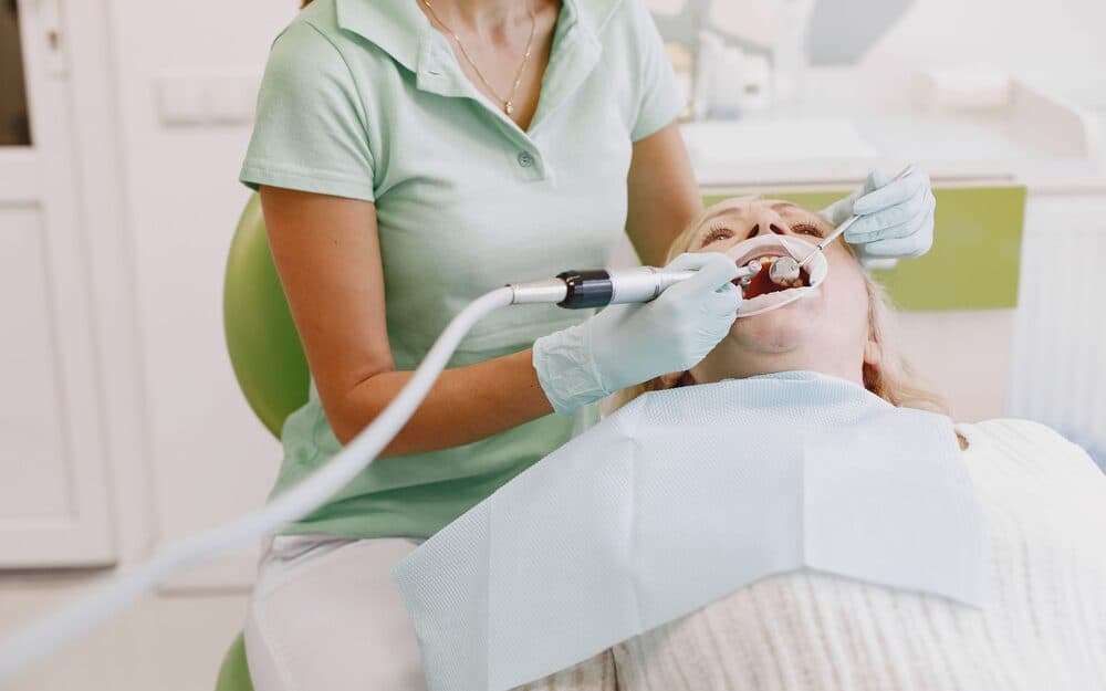 A dental hygienist cleaning a patient's teeth
